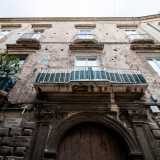 Nei due piani superiori si apre invece una serie parallela di finestroni architravati con piccoli balconi sorretti da mensole